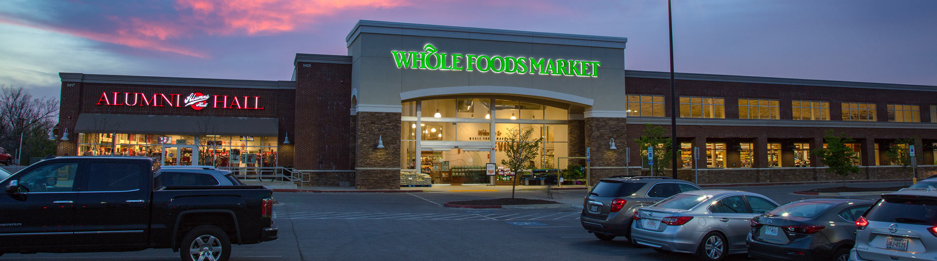 A Whole Foods storefront against a purple evening sky